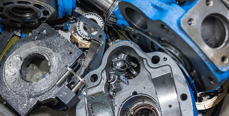 Disassembled hydraulic pump parts, including metal components and blue casings.